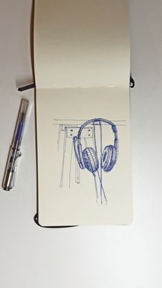 a notepad with headphones drawn on it next to a pen and paper roll