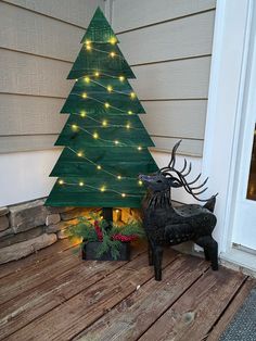 a christmas tree with lights is on the porch next to a potted planter