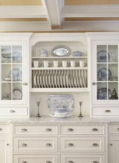 a white china cabinet with dishes on it