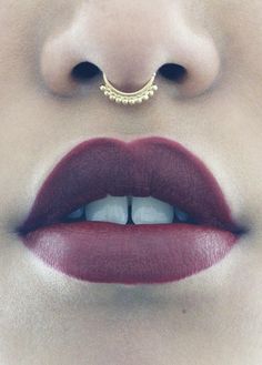 a woman's lips and nose piercings are shown