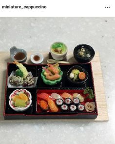 an assortment of sushi on a wooden tray