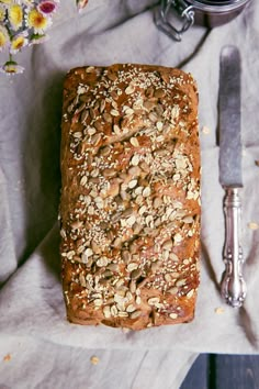 a loaf of bread sitting on top of a table next to a knife and fork