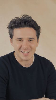 a man smiling while sitting at a table