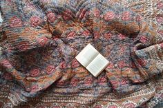 an open book laying on top of a blanket