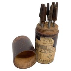 an old tin can with several wooden knives sticking out of it's top and bottom