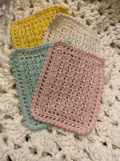 three crocheted coasters sitting on top of a blanket