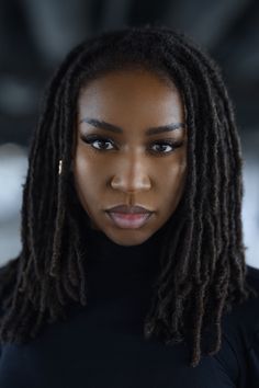 a woman with dreadlocks looking at the camera