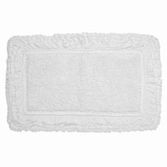 a white bath mat with ruffled edges