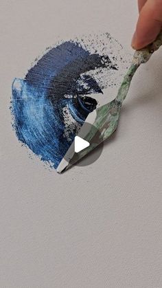 someone is using a paintbrush to draw something blue