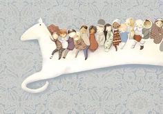 a group of teddy bears riding on the back of a white horse