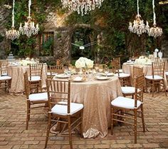 an outdoor dining area with tables and chairs, chandeliers hanging from the ceiling