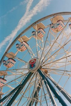 a ferris wheel with blue sky and clouds in the background