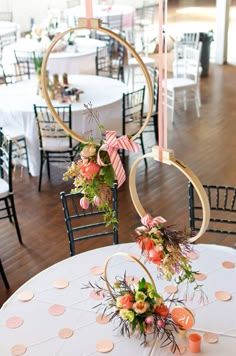 the tables are decorated with floral centerpieces and gold hoop decorations for an elegant touch