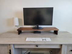 a computer monitor sitting on top of a wooden desk next to a keyboard and mouse