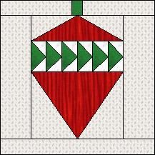 a red and green christmas ornament on a white quilted background with black border