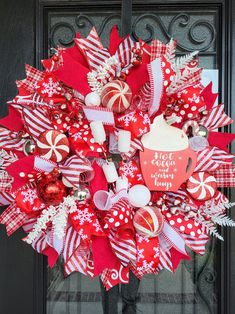 a red and white christmas wreath with candy canes, candies and ornaments on the front door