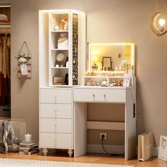 a white desk with drawers and lights on it in front of a closet filled with clothes