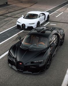 two black and white bugatti cars driving down the road in front of each other