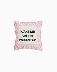 a pink and white pillow with the words wake me when i'm famous on it