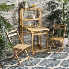 three wooden chairs and a table in front of a brick wall with potted plants