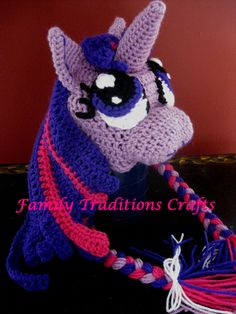 a crocheted hat with an animal on it's head and tassel