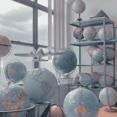 there are many globes on the shelves in this room and one is upside down