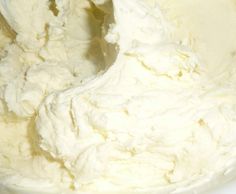 a white bowl filled with whipped cream on top of a table