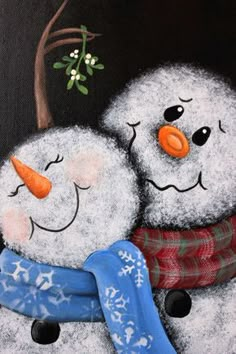 two snowmen are hugging each other in front of a black background with green leaves