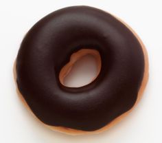 a chocolate frosted donut on a white surface