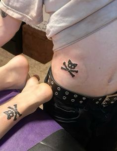 a woman getting her tattoo done by someone else on her stomach and the other leg behind her