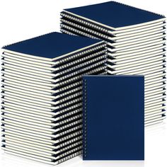 a stack of blue notebooks sitting next to each other on top of a white surface