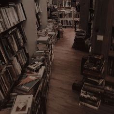 a long row of books on shelves in a room with wood flooring and wooden floors