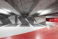 an empty parking garage with red and white flooring