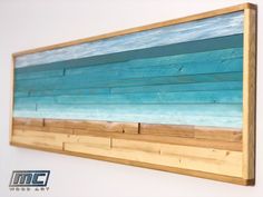 a wooden wall hanging on the side of a white wall with blue and green paint