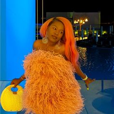 a woman with orange hair is standing in front of a pool