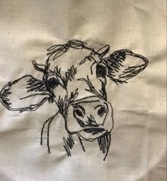 a drawing of a cow is shown on a piece of cloth that has been stitched together