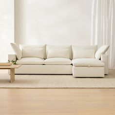 a white couch sitting on top of a hard wood floor next to a wooden table