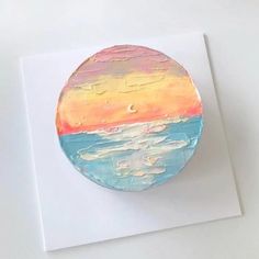 a painted disc sitting on top of a piece of paper