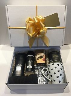 an open gift box with coffee, mugs and other items in the bottom right corner