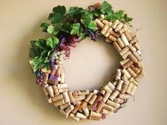 a wreath made out of wine corks and leaves on a wall with the letter o