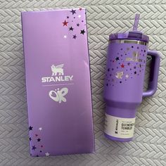 a purple travel mug next to a box