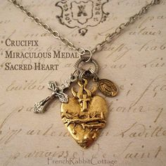 "Catholic Assemblage Necklace featuring * Sacred Heart, * Miraculous Medal, and * Crucifix. This necklace features 3 of the most beloved and meaningful Catholic icons: * a pewter Sacred Heart of Jesus, plated in gold tone. (1 1/8\" tall) It is very detailed, showing the flaming heart, crown of thorns, and cross. * a beautifully detailed, petite Crucifix, made in Italy. (7/8\" tall) This silver tone crucifix is Very Lightweight. * a petite, brass Miraculous Medal with full detail on front and bac Luxury Crucifix Necklaces For Gift, Cheap Personalized Crucifix Jewelry, Catholic Icons, Sacred Jewelry, Flaming Heart, Grunge Jewelry, Heart Crown, Assemblage Necklace, Sacred Heart Of Jesus