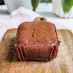 a piece of brownie sitting on top of a wooden cutting board