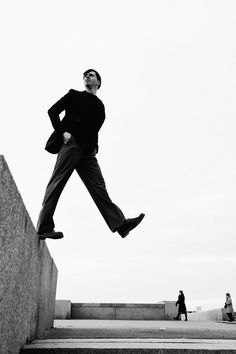 black and white photograph of a man jumping up stairs