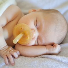 a baby laying down with a pacifier in its mouth