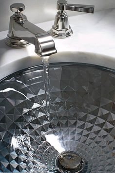 a chrome faucet with water running from it's spout into the sink