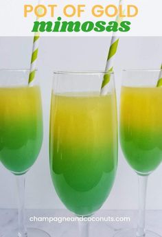 two glasses filled with green and yellow liquid next to each other on a white table