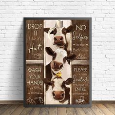 two cows are standing next to each other in front of a brick wall with words on it