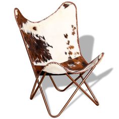 a brown and white chair sitting on top of a metal frame with a cow print seat cover