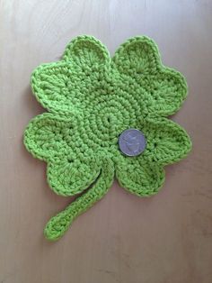 a green crocheted flower with a button on it